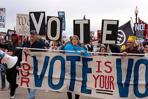 Demonstrators hold up banners as they march across the Memorial Bridge during a "No Kings" protest in Washington, Saturday, Oct. 17, 2026.