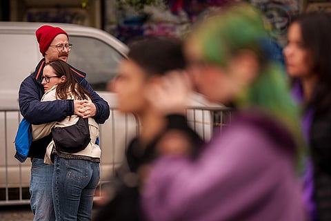 A man hugs a woman during a protest aiming to raise awareness to the violence and prejudice against women in Romanian society, in Bucharest, Romania, Saturday, Oct. 17, 2026.