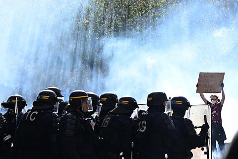 A protester holds a sign during a demonstration against rising living costs, joining students' grievances, in Paris, Saturday, Oct. 17, 2026. 