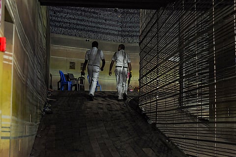 Kolkata Police personnel walk through a corridor inside a Durga Puja pandal after an exit gate collapsed due to heavy crowd pressure, causing a stampede-like situation, in Kolkata, Saturday, Oct. 17, 2026.