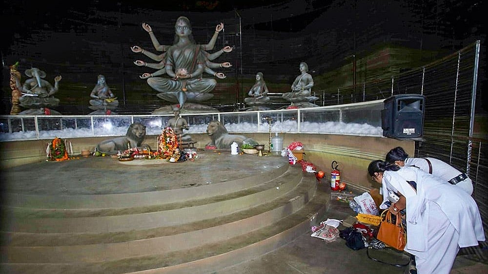 Kolkata Police personnel examine scattered belongings inside Durga Puja pandal  - | Photo: PTI 