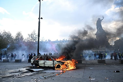 A car burns at Place de La Republique during a protest against rising living costs in Paris, Saturday, Oct. 17, 2026.