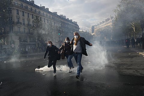 Protesters run to leave the Republique square during a demonstration against rising living costs, joining students' grievances, in Paris, Saturday, Oct. 17, 2026.