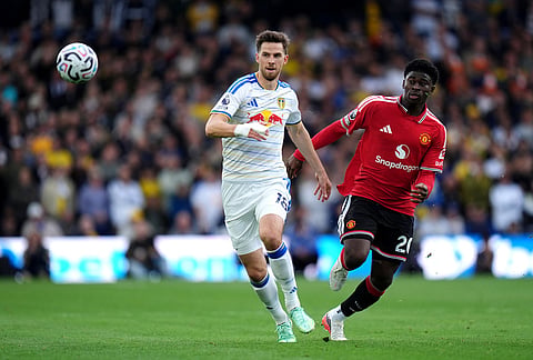 Leeds United's Anton Stach, left, and Manchester United's Carlos Baleba battle for the ball during the English Premier League soccer match between Leeds United and Manchester United in Leeds, England, Sunday, Oct. 18, 2026.
