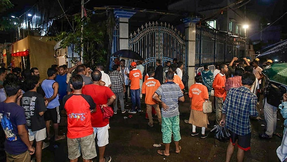 Volunteers and people gather outside the Durga Puja pandal following a stampede-like situation after an exit gate collapsed due to heavy crowd pressure - Photo: PTI