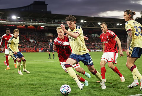 Arsenal's Declan Rice, centre, challenges for the ball with Nottingham Forest's Xaver Schlager during the English Premier League soccer match between Nottingham Forest and Arsenal in Nottingham, England, Sunday, Oct. 18, 2026. 