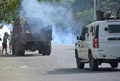 Police fire tear gas shells to disperse irate locals who placed the bodies of two victims, allegedly killed in an ambush by armed miscreants at Sunurok Uyok in Imphal East district, in front of the Chief Minister's bungalow, in Imphal.
