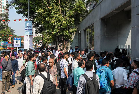 People gather after a fire broke out in the kitchen of a hotel on the first floor of Kohinoor Square, at Dadar West, in Mumbai.