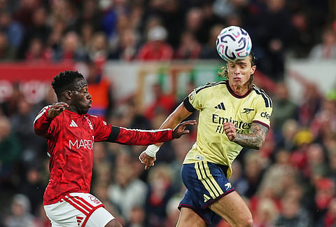 Arsenal's Riccardo Calafiori, right, challenges for the ball with Nottingham Forest's Arnaud Kalimuendo during the English Premier League soccer match between Nottingham Forest and Arsenal in Nottingham, England, Sunday, Oct. 18, 2026. 
