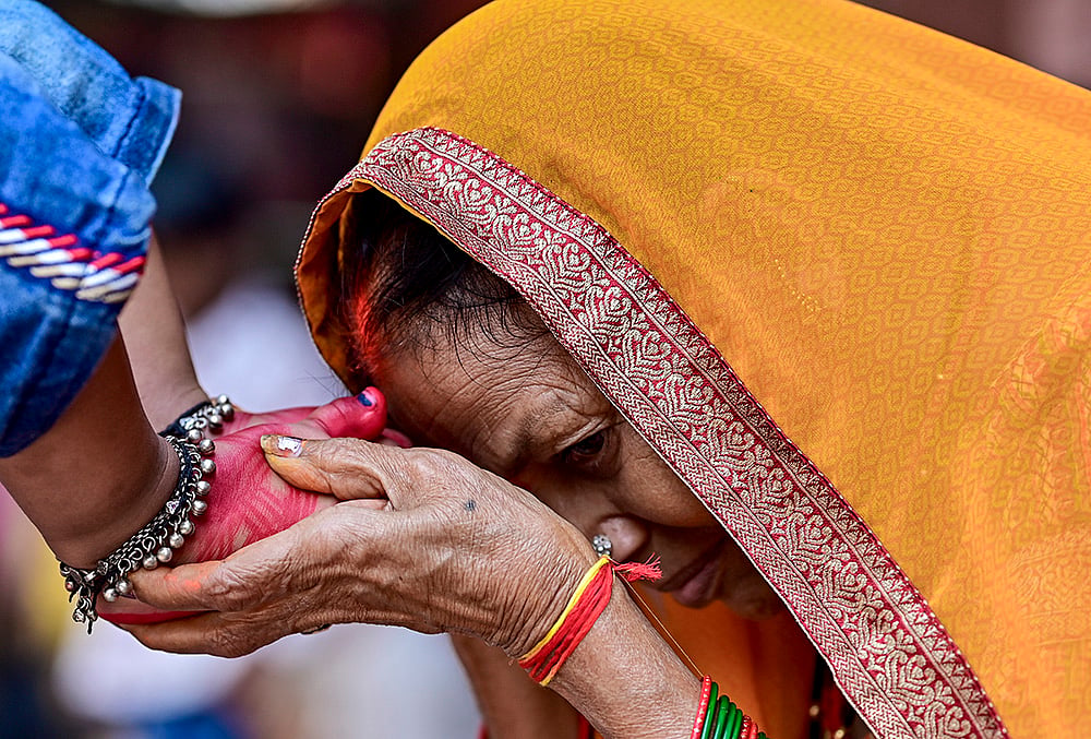 A woman seeks blessings of a young girl during 'Kanya Pujan' rituals on of Maha Navami, as part of the Navratri festival, in Prayagraj.
 - | Photo: PTI 