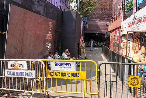 Police personnel sit outside the Chorbagan Sarbojanin Durga Puja pandal following a recent stampede-like situation, in Kolkata.
