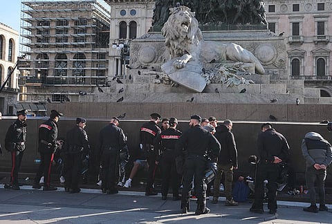 Carabinieri officers talk to people in Duomo square, Milan, Italy, a day after rioters clashed with police, looted stores and set property on fire, Monday, Oct. 19, 2026. 

