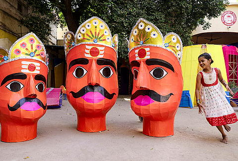A child runs around effigies of Demon King Ravan at a workshop ahead of Dussehra festival, in Hyderabad, Sunday, Oct. 18, 2026. 
