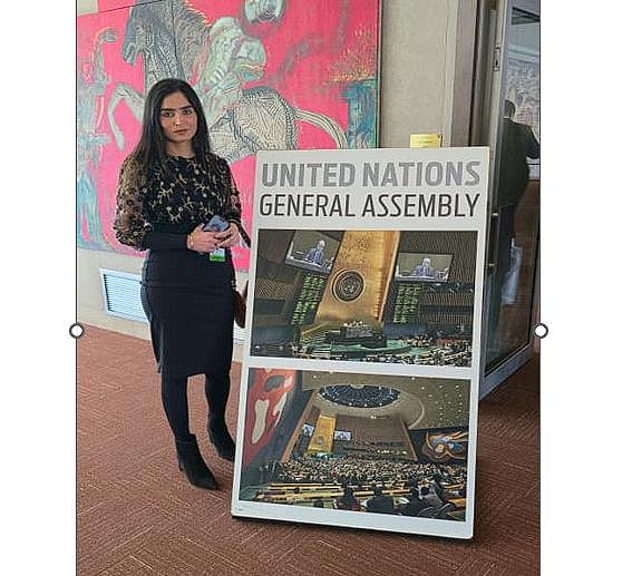 Nidhi Kar standing next to a United Nations General Assembly sign