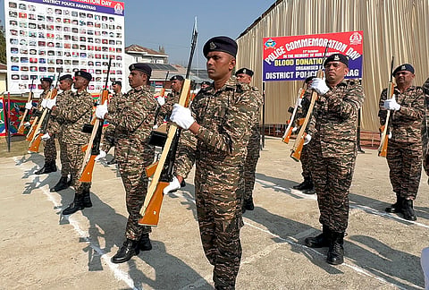Police personnel pay tributes during the Police Commemoration Day parade, in Anantnag, Jammu and Kashmir. 
