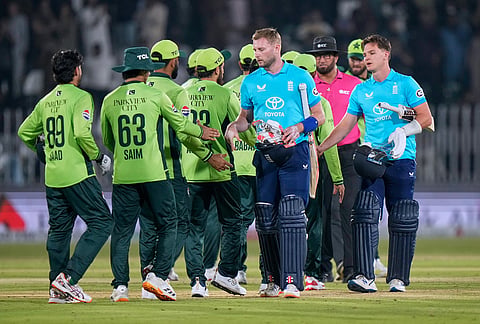 England's Gus Atkinson, fourth right, and Sonny Baker, right, shakes hand with Pakistani players on the end of the tri-series one-day international cricket match between Pakistan and England, in Rawalpindi, Pakistan, Tuesday, Oct. 20, 2026. 
