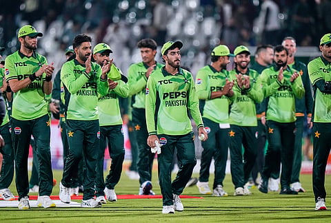 Pakistan's players clap for teammate Arafat Minhas, center, who took the six wickets, on the end of the tri-series one-day international cricket match between against England, in Rawalpindi, Pakistan, Tuesday, Oct. 20, 2026. 