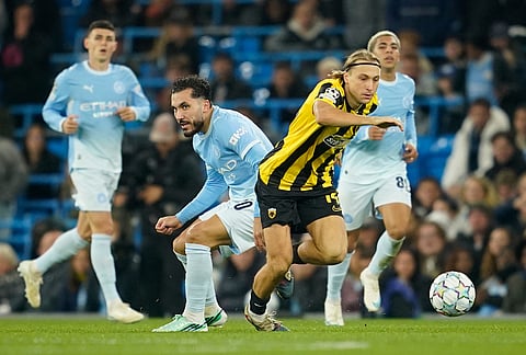 AEK Athens' Lovro Majer passes Manchester City's Rayan Cherki during the Champions League soccer match between Manchester City and AEK Athens in Manchester, England, Tuesday, Oct. 20, 2026.
