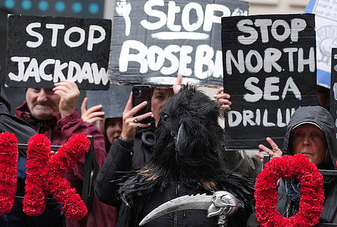Activists protest against the government's approval of a natural gas project off Scotland's coast at the Department for Energy Security and Net Zero in London, Wednesday, Oct. 21, 2026. 