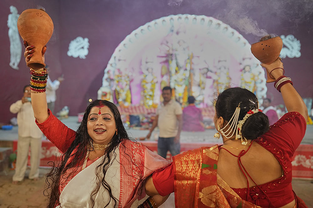 Hindu devotees performs a traditional Dhunuchi dance inside a temporary worship venue of goddess Durga during Durga Puja celebrations on the last day of Durga Puja festival in Prayagraj, in the northern Indian state of Uttar Pradesh, Tuesday, Oct. 20, 2026. - | Photo: AP/Rajesh Kumar Singh