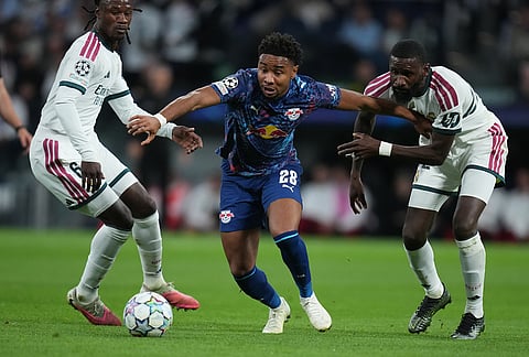Leipzig's Christopher Nkunku, center, challenges for the ball with Real Madrid's Eduardo Camavinga, left, and Real Madrid's Trent Alexander-Arnold during the Champions League opening phase soccer match between Real Madrid and Leipzig in Madrid, Wednesday, Oct. 21, 2026. 