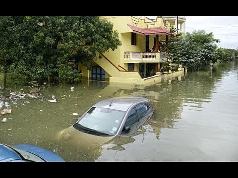 A car submerged in floodwaters in front of inundated houses following heavy rains in Puducherry - Special Arrangement
