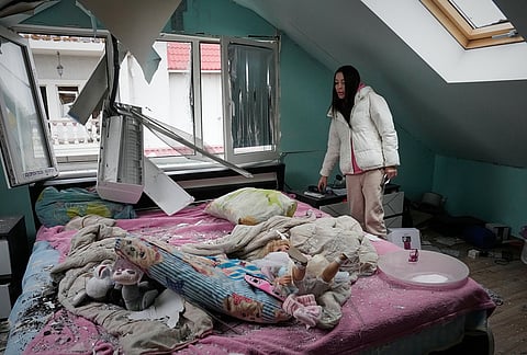 A woman looks at her damaged apartment after a Russian missile attack in Kyiv, Ukraine, Thursday, Oct. 22, 2026. 