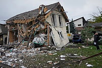 | Photo: AP/Efrem Lukatsky : A woman looks at residential house destroyed in a Russian missile strike in Kyiv, Thursday, Oct. 22, 2026. 