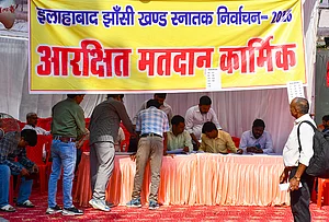 | Photo: PTI : Polling officials collect the election materials on the eve of voting in the legislative council elections across teachers and graduate constituencies, in Prayagraj.