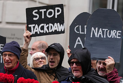 Activists protest against the government's approval of a natural gas project off Scotland's coast at the Department for Energy Security and Net Zero in London, Wednesday, Oct. 21, 2026. 