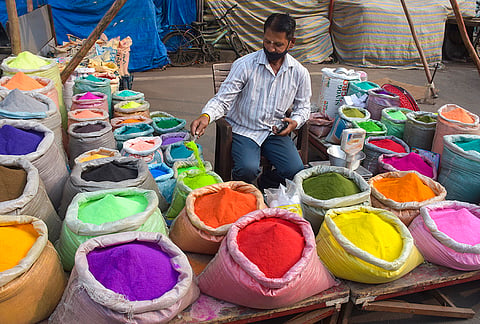 A vendor arranges rangoli colours for sale ahead of the ‘Diwali’ festival, in Surat.