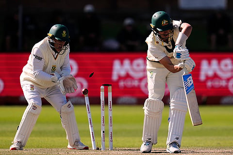 Australia's captain Pat Cummins, right, is bowled as South Africa's Ryan Rickelton plays behind the wicket on day five of the second cricket test match between South Africa and Australia, in Gqeberha, South Africa, Thursday, Oct. 22, 2026.