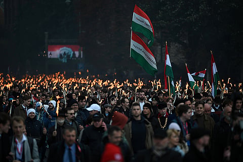 Participants carry torches during a traditional march in Budapest marking the 70th anniversary of the 1956 Hungarian Revolution against Soviet rule in front of the Budapest University of Technology and Economics in Budapest, Hungary, Thursday, Oct. 22, 2026.