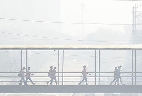 Commuters use a foot overbridge amid smog, in Gurugram, Haryana, Thursday, Oct. 22, 2026. 
