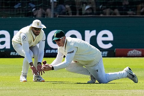 South Africa's Simon Harmer, right, attempts to field the ball as South Africa's Aiden Markram covers him on day five of the second cricket test match between South Africa and Australia, in Gqeberha, South Africa, Thursday, Oct. 22, 2026.