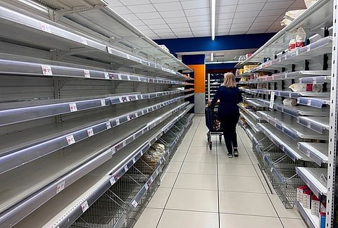 A woman walks past empty shelves at a supermarket in Naples, Italy, Tuesday, Oct. 20, 2026. 
