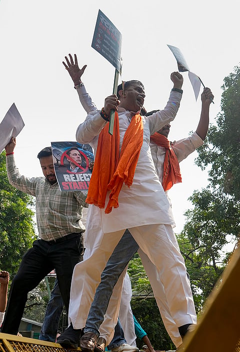 Swadeshi Jagran Manch (SJM) members hold placards as they climb atop barricades during a protest march against Starlink, the satellite-based internet service owned by industrialist Elon Musk, in New Delhi, Friday, Oct. 23, 2026. 
