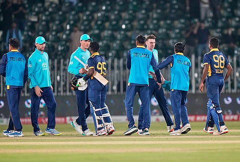 Sri Lanka's Janith Liyanage, center, and teammates shake hand with England players on the end of the tri-series one-day international cricket match between Sri Lanka and England, in Rawalpindi, Pakistan, Thursday, Oct. 22, 2026. 