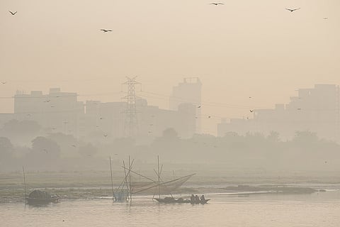 People row a boat amid haze on the Yamuna river, in New Delhi. Delhi's air quality remains in the 'Poor' category with an AQI hovering around 166-180 under GRAP Stage I anti-pollution restrictions.