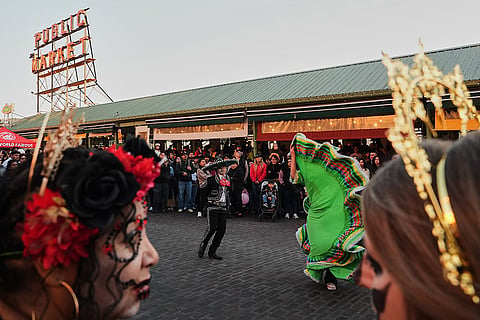 People watch a performance by the Santana Charro Bros., a Mexican folklore youth dance group, during a Día de Muertos celebration at Pike Place Market, Friday, Oct. 23, 2026, in Seattle.