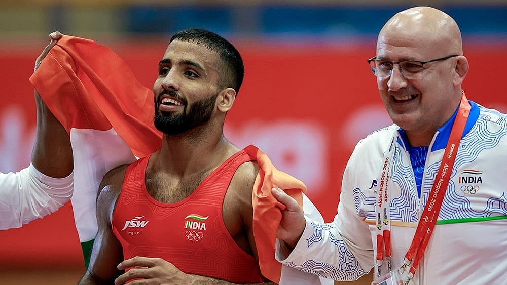 India's Sujeet Kalkal with coach after winning gold medal in the men's Freestyle 65 kilogram final bout 196 wrestling event in the ongoing Asian Games 2026, in Nagoya, Japan, Friday, Oct. 2, 2026. 
 - | Photo: PTI/Arun Sharma