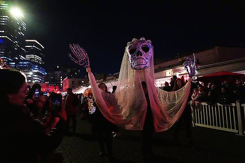 A calavera puppet passes by in a parade during a Día de Muertos celebration at Pike Place Market, Friday, Oct. 23, 2026, in Seattle.