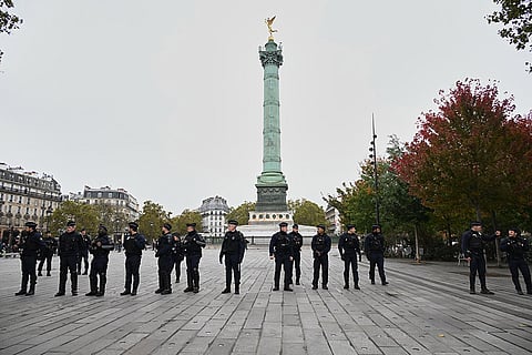 Police officers patrol the empty Place de la Bastille ahead of a demonstration against rising living costs in Paris, Saturday, Oct. 24, 2026.