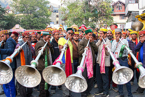 Musicians play traditional instruments as palanquins carrying idols arrive to participate in a religious procession, in Kullu, Himachal Pradesh.