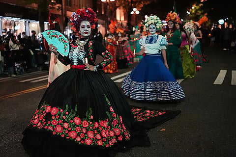 Dozens of women dressed as Catrinas participate in a parade during a Día de Muertos celebration at Pike Place Market, Friday, Oct. 23, 2026, in Seattle.
