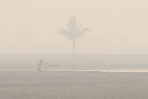 A fisherman casts a net amid thick haze from forest fires in Ogan Ilir, South Sumatra, Indonesia, Thursday, Oct. 22, 2026. 
