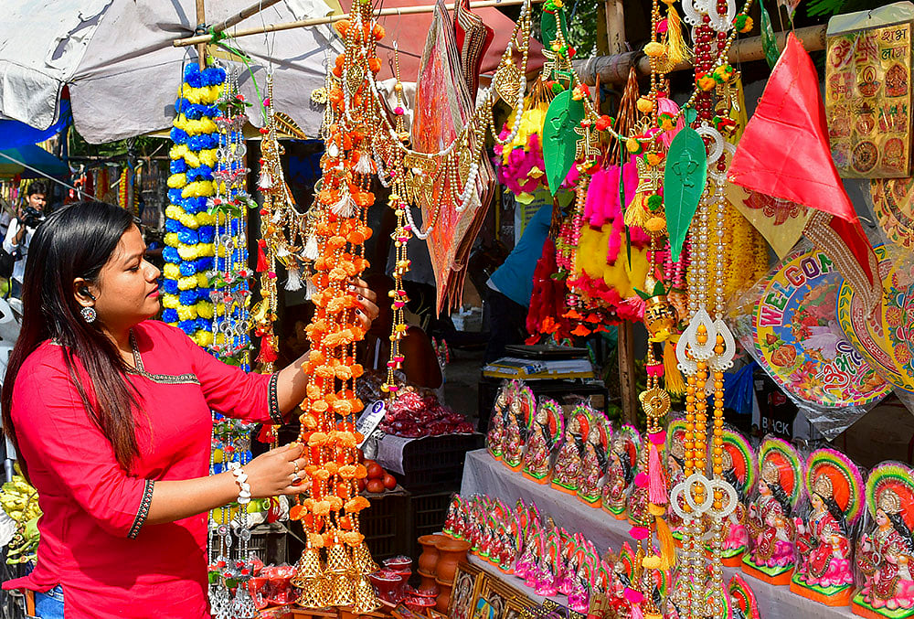 A woman looks on at decorative items ahead of Lakshmi Puja festival, in Guwahati, Assam, Saturday, Oct. 24, 2026. 
 - | Photo: PTI 
