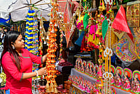 | Photo: PTI  : A woman looks on at decorative items ahead of Lakshmi Puja festival, in Guwahati, Assam, Saturday, Oct. 24, 2026. 
