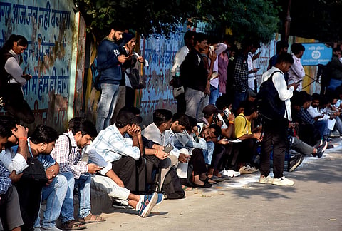 Candidates do last-minute preparations outside an examination centre before entering to appear for the Uttar Pradesh Subordinate Services Selection Commission Preliminary Eligibility Test (UPSSSC PET) examination, in Moradabad, Uttar Pradesh.