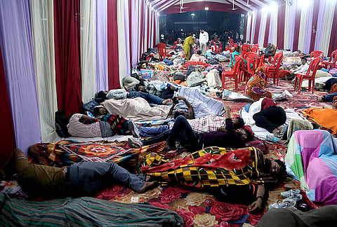 Aspirants of the Uttar Pradesh Subordinate Services Selection Commission Preliminary Eligibility Test (UPSSSC PET) sleep with family members under a tent set up by the district administration at Mathura Junction railway station, ahead of the examination, in Mathura, Uttar Pradesh.
